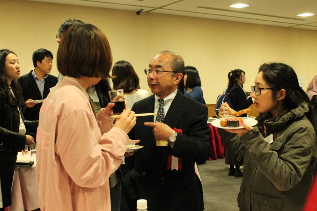 会場の様子（新入留学生と歓談する岡田円治如水会事務局長）