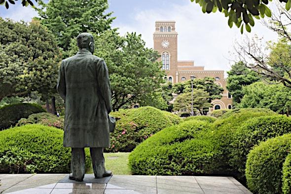 先生の銅像と一橋大学附属図書館 の写真